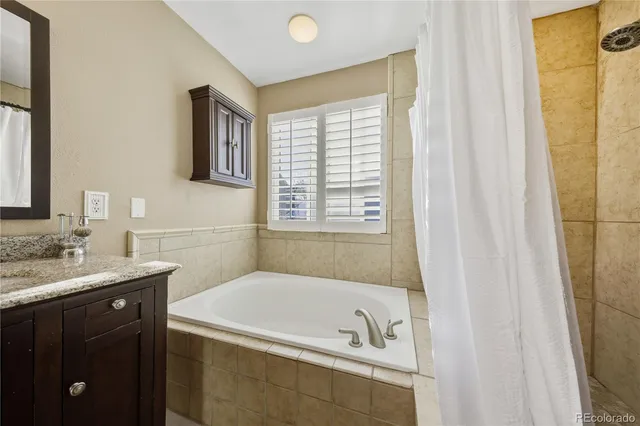 a bathroom with a tub a sink and a window