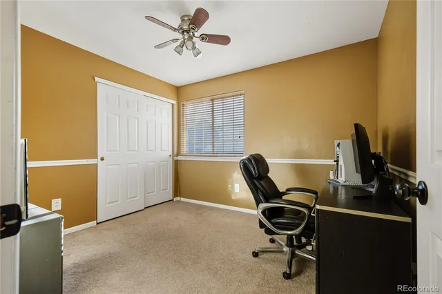 a view of a workspace with furniture and a window
