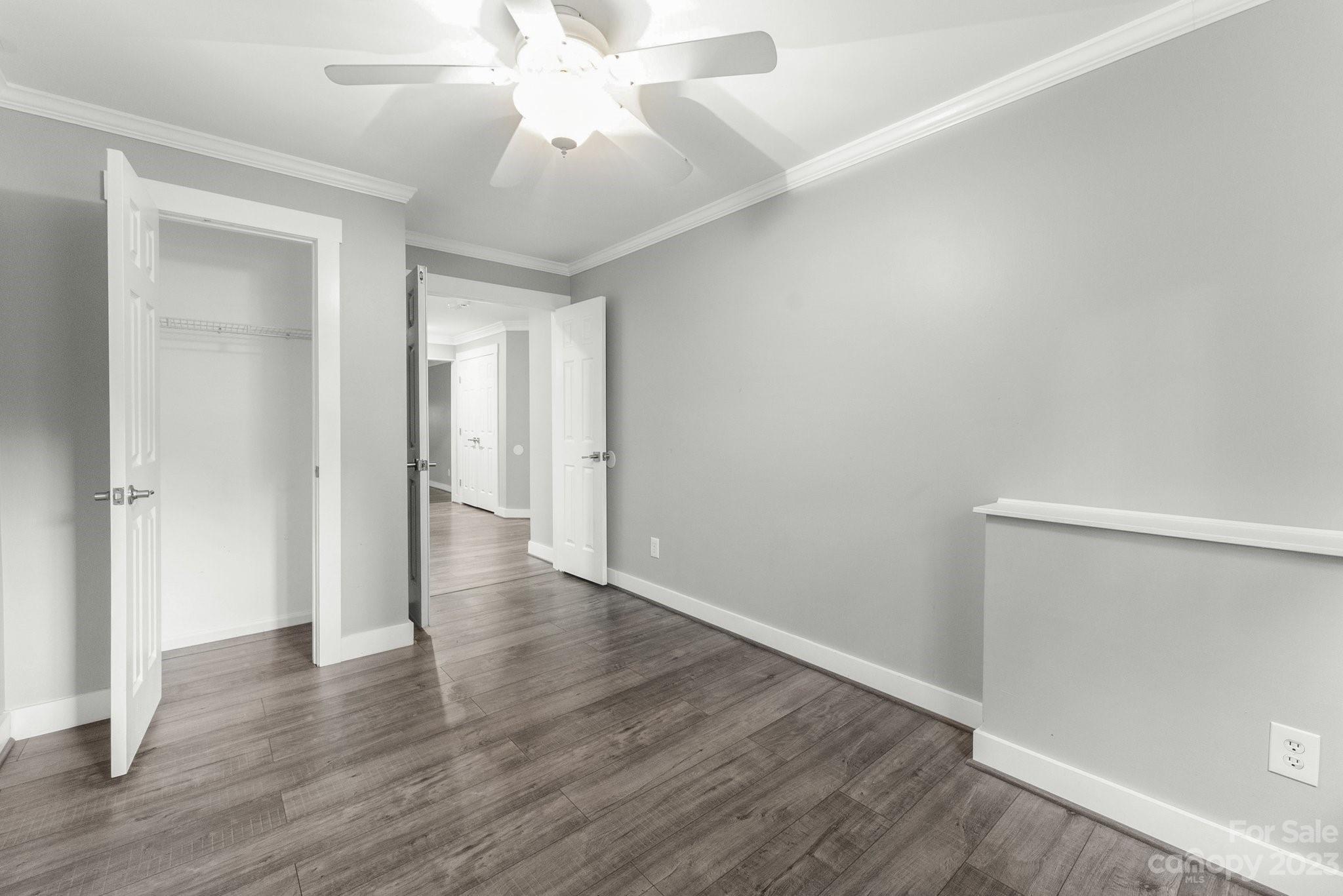 19905 Henderson Road, Unit A Cornelius, NC 28031 - Photo 20 of 46 an empty room with wooden floor and a ceiling fan