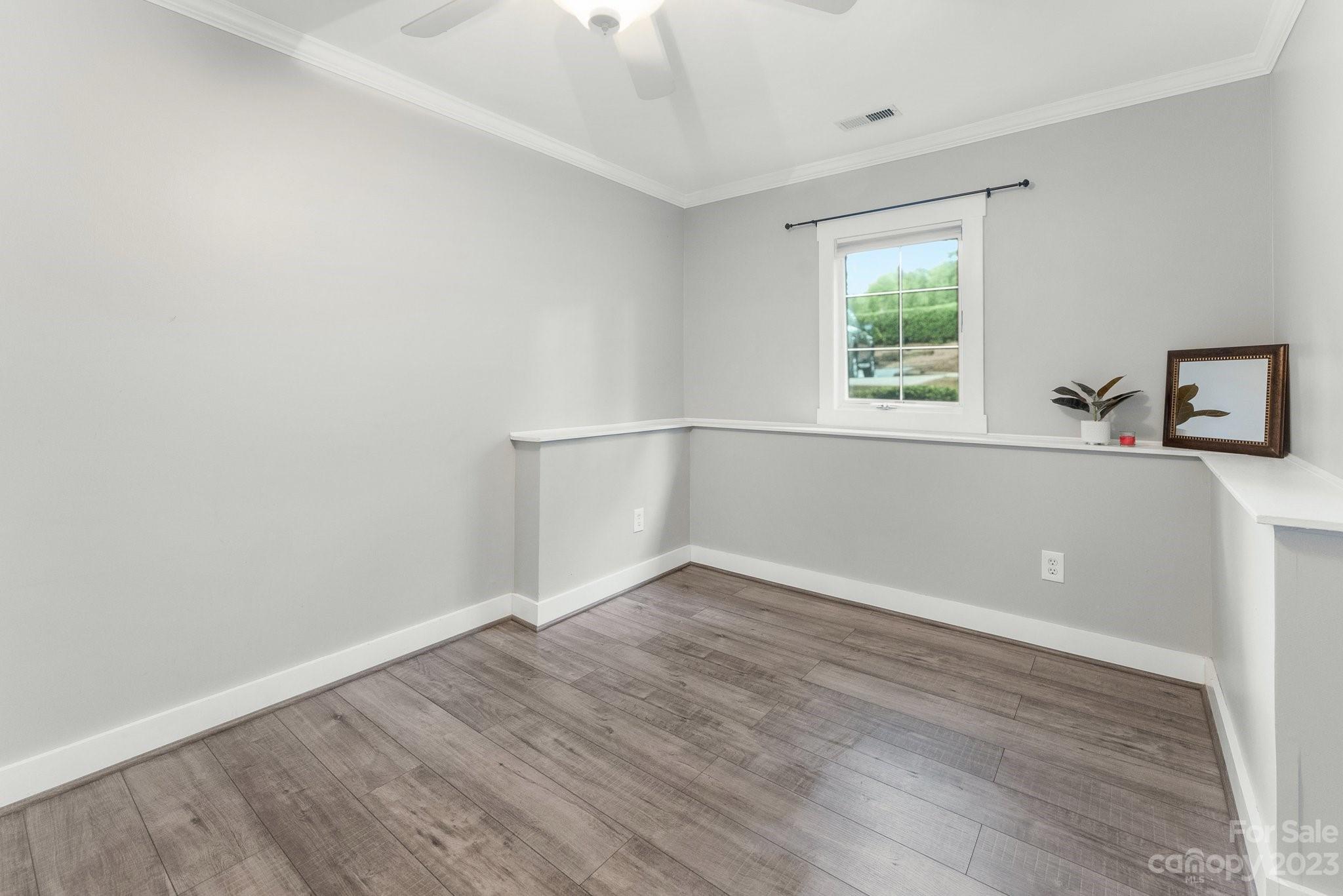 19905 Henderson Road, Unit A Cornelius, NC 28031 - Photo 21 of 46 an empty room with wooden floor and windows