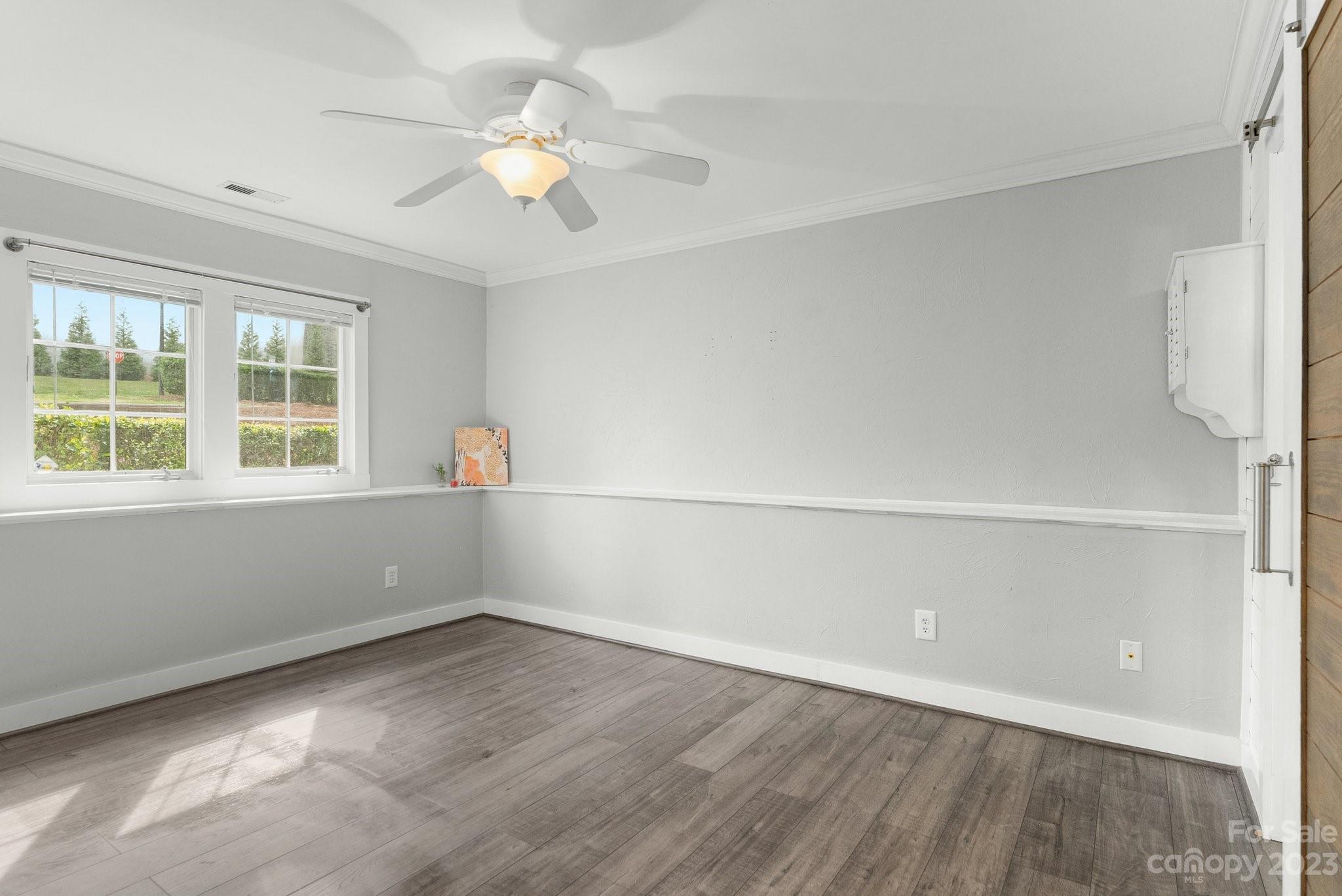 19905 Henderson Road, Unit A Cornelius, NC 28031 - Photo 10 of 46 an empty room with a window and a ceiling fan