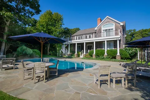 a view of a house with backyard sitting area and garden