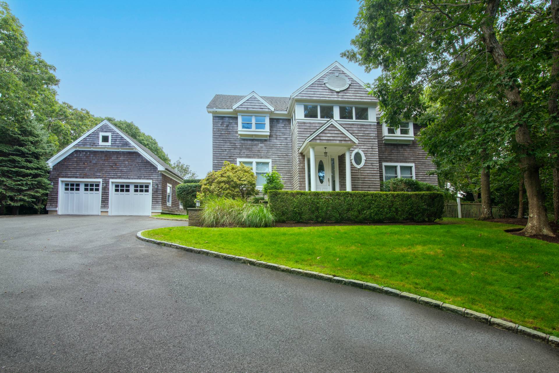 23 Sycamore Lane Montauk, NY 11954 - Photo 2 of 33 a front view of a house with a yard and garage