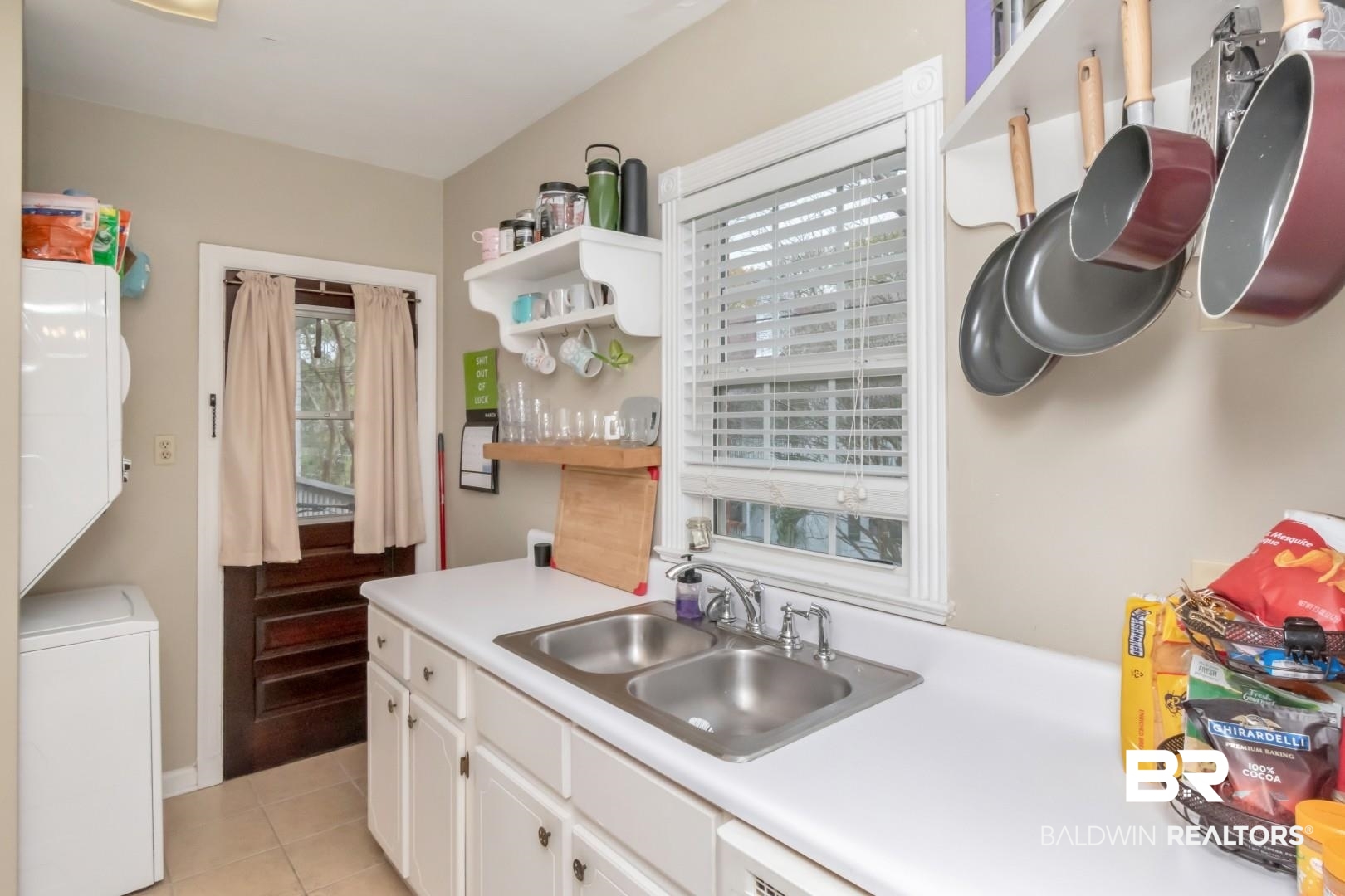 214 Upham Street, Unit 17C Mobile, AL 36607 - Photo 14 of 32 Kitchen featuring open shelves, washer / clothes dryer, light countertops, white cabinets, and light tile patterned floors