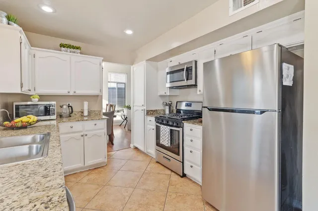 a kitchen with white cabinets and stainless steel appliances