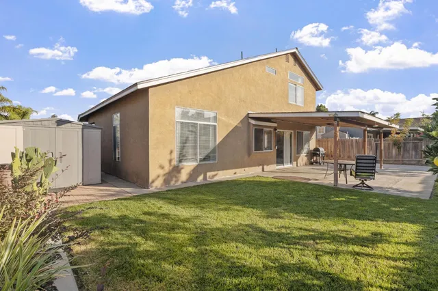 a view of a house with backyard and sitting area