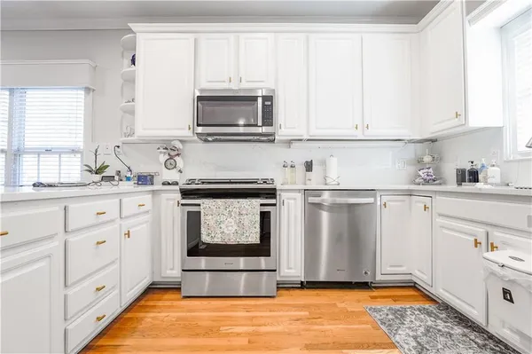 a kitchen with white cabinets and sink