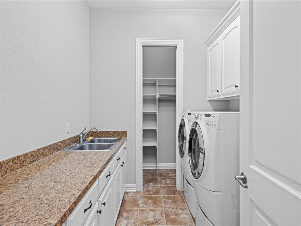 107 Marina Del Ray Bridgeport, TX 76426 - Photo 28 of 40 a bathroom with a granite countertop sink and a washer dryer