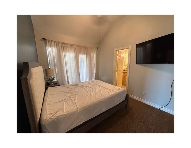 a bedroom with a bed and a television