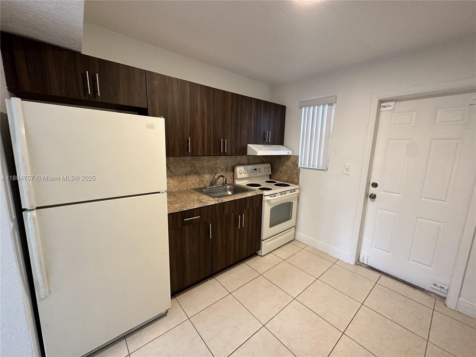 1851 Ali Baba Avenue, Unit 4 Opa-Locka, FL 33054 - Photo 3 of 6 a white refrigerator freezer and a stove in a kitchen