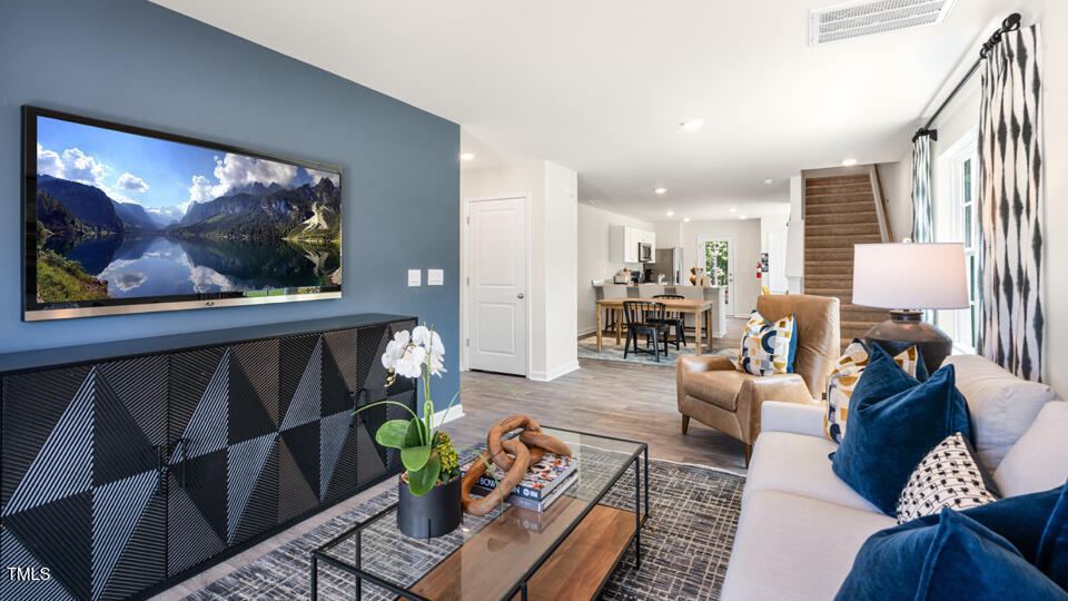 8519 Beckett Chase Way Raleigh, NC 27616 - Photo 12 of 29 a living room with furniture a dining table and a painting on the wall