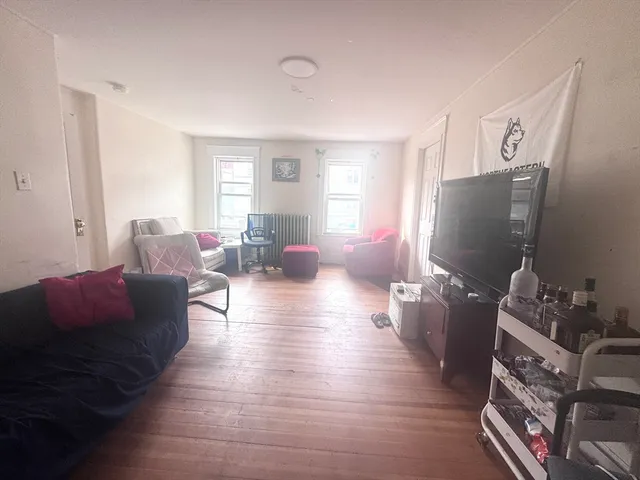 a living room with furniture wooden floor and a flat screen tv