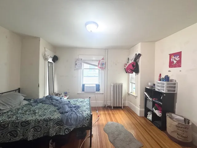 a bedroom with a bed and wooden floor