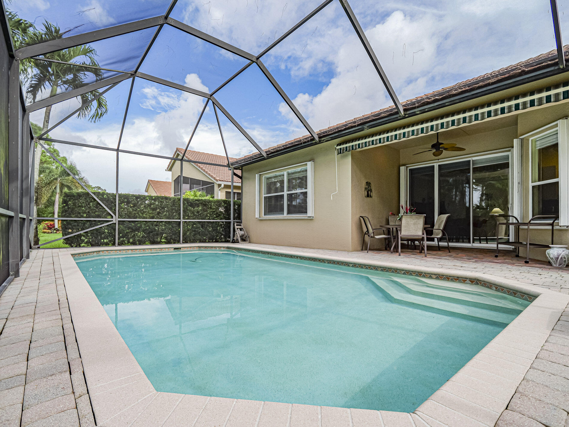 6871 Southeast Twin Oaks Circle Stuart, FL 34997 - Photo 24 of 34 a view of a backyard with table and chairs under an umbrella