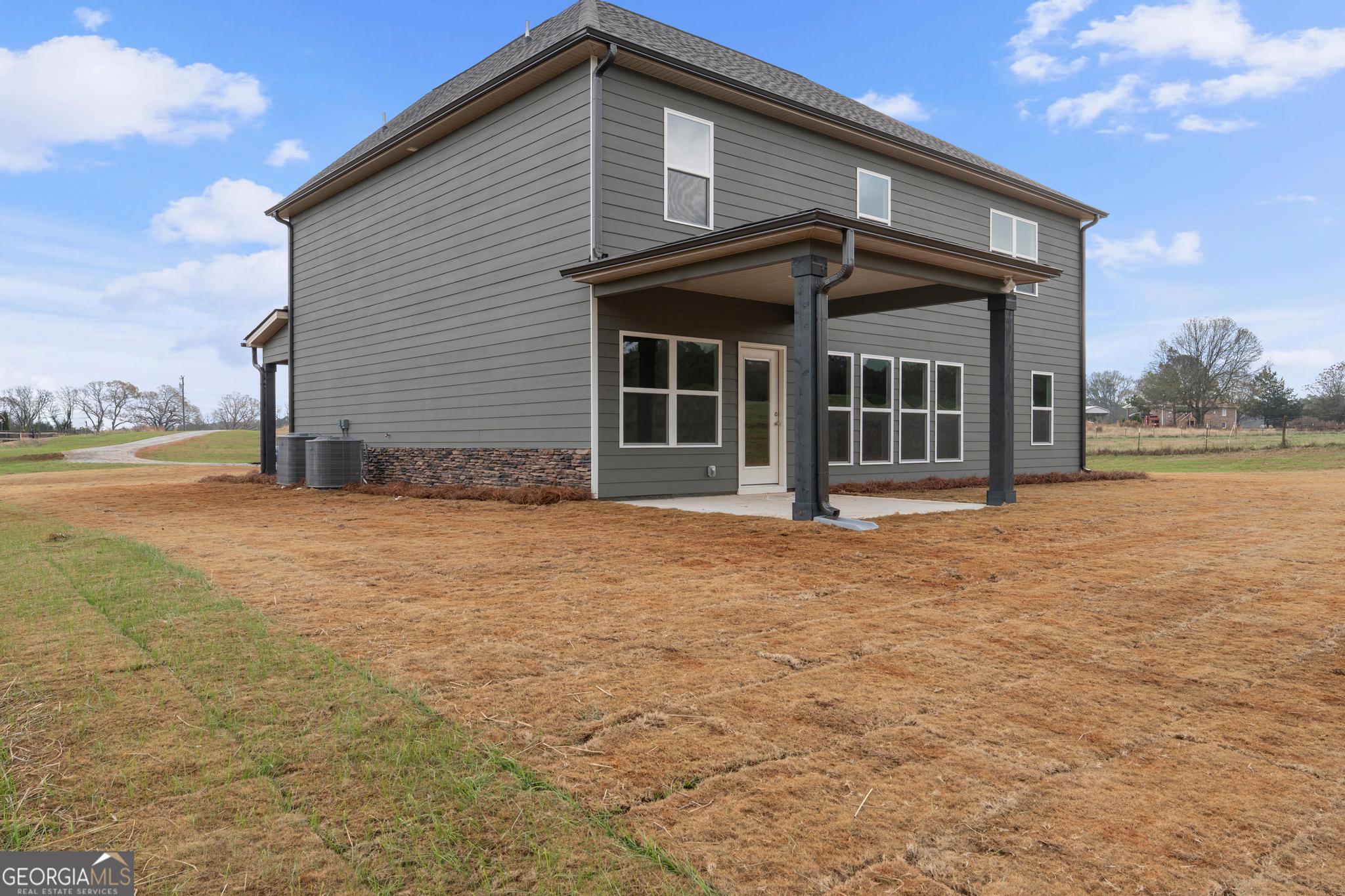 2305 New Hope Road, Unit (LOT 5) Locust Grove, GA 30248 - Photo 9 of 45 a front view of a house with a garden