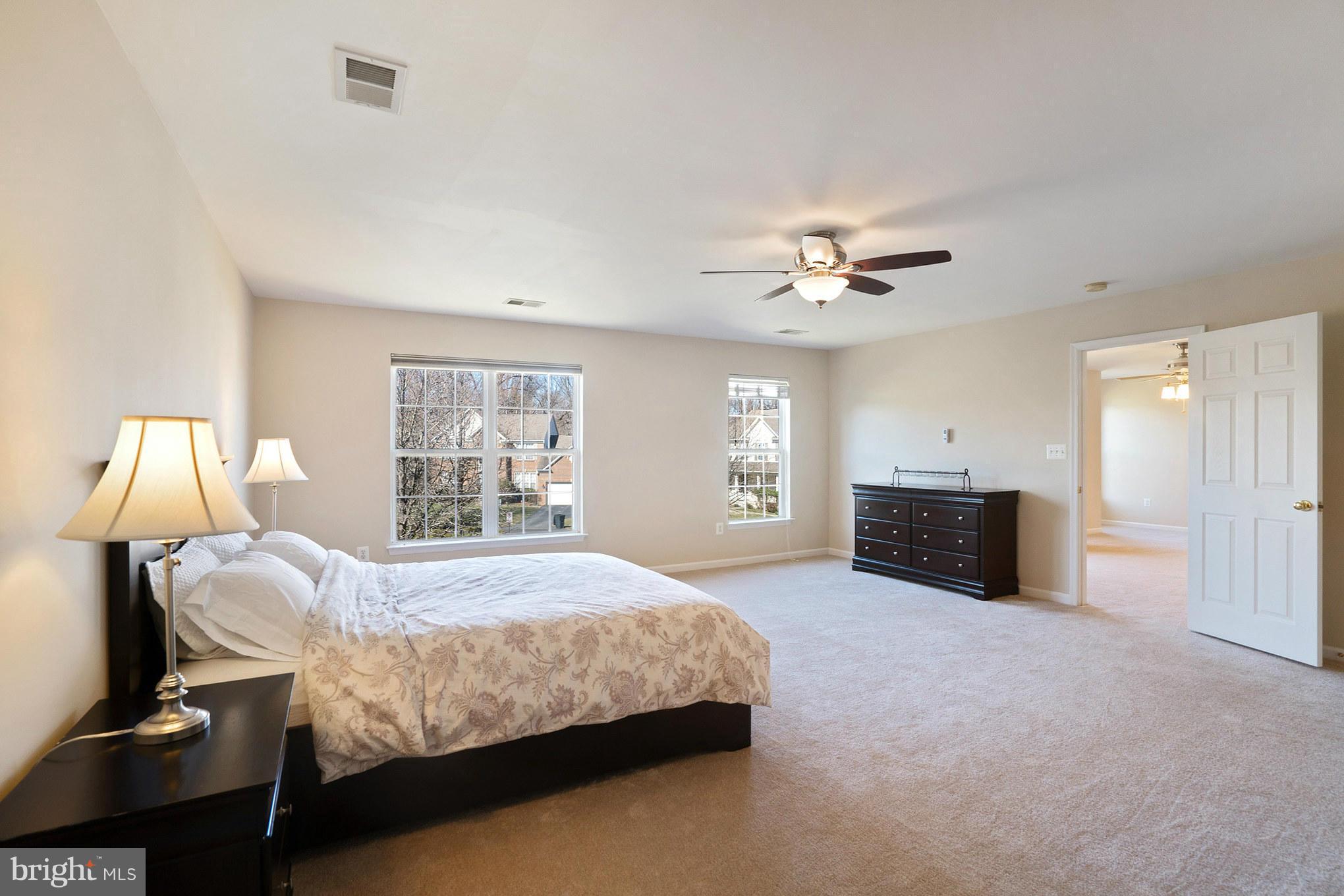 14202 Brass Wheel Road Boyds, MD 20841 - Photo 15 of 27 a bedroom with a bed and a chandelier