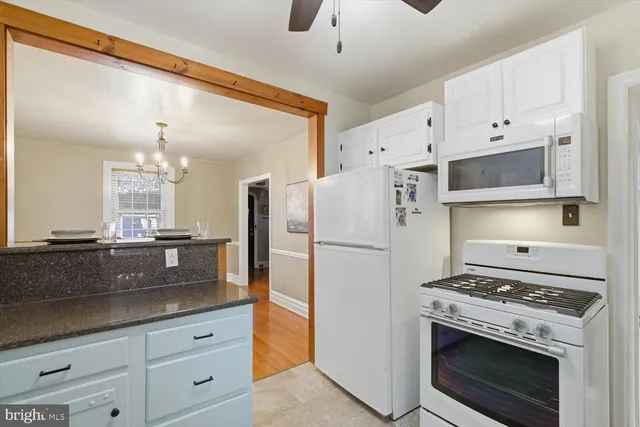 a kitchen with refrigerator a stove a sink and cabinets