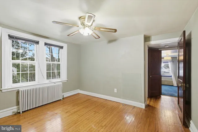 an empty room with a ceiling fan and wooden floor