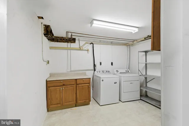 a view of a house with a small yard and a large tree