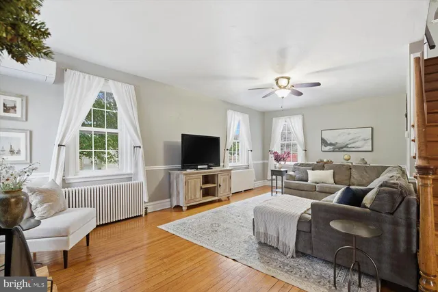 a living room with furniture a flat screen tv and a large window