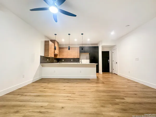 a large kitchen with stainless steel appliances a large counter top a stove and a refrigerator
