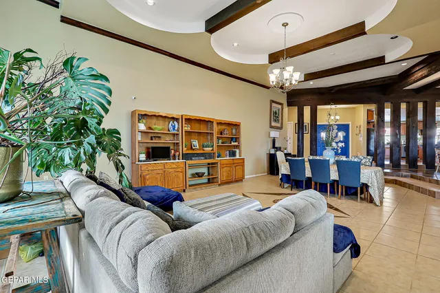 a kitchen with stainless steel appliances granite countertop a sink dishwasher and a flat tv screen next to a large window with wooden floor