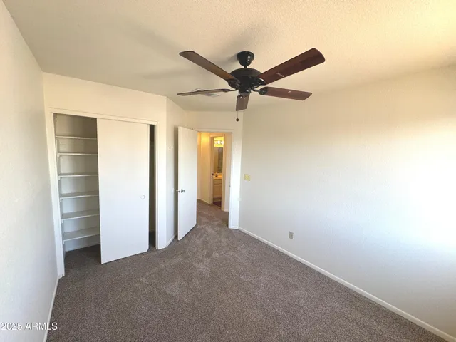a view of a big room with a ceiling fan and a window