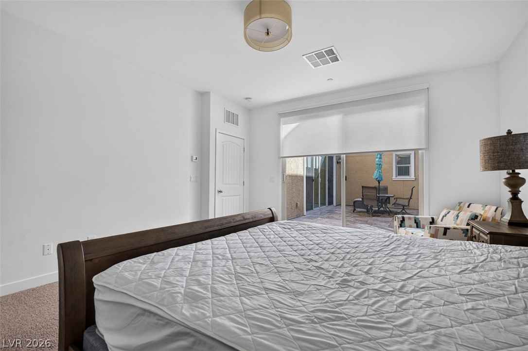 1100 East Sunset Road Henderson, NV 89011 - Photo 18 of 58 Step into this comfortable bedroom with direct access to a tranquil outdoor patio.