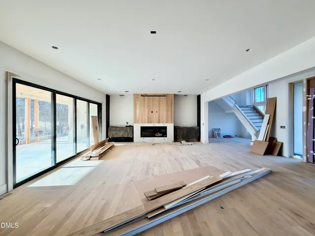 a view of an empty room with a fireplace and a window