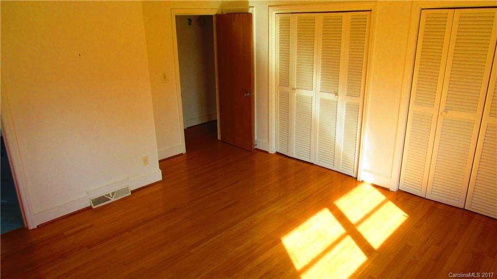 4901 Cheviot Road Charlotte, NC 28269 - Photo 17 of 23 an empty room with wooden floor and a window