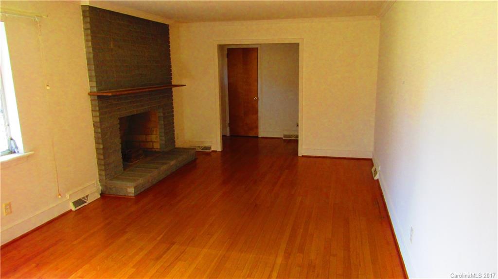 4901 Cheviot Road Charlotte, NC 28269 - Photo 7 of 23 a view of a livingroom with wooden floor and a hallway