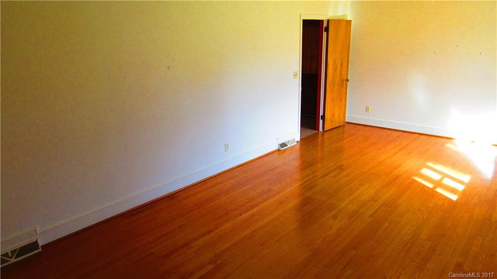 4901 Cheviot Road Charlotte, NC 28269 - Photo 8 of 23 an empty room with wooden floor
