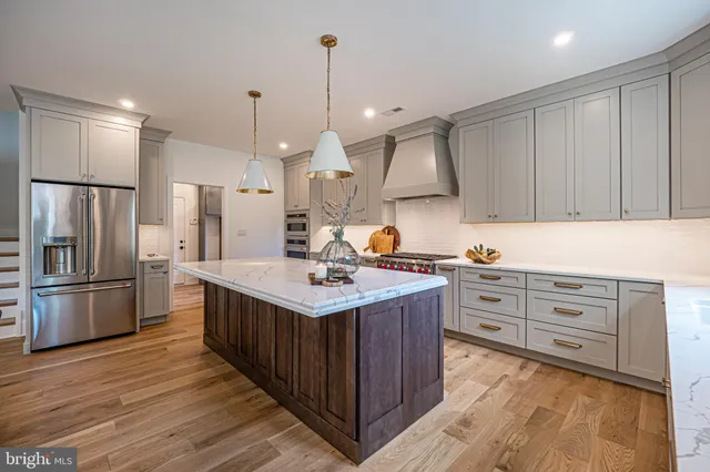 a kitchen with a table chairs refrigerator and cabinets