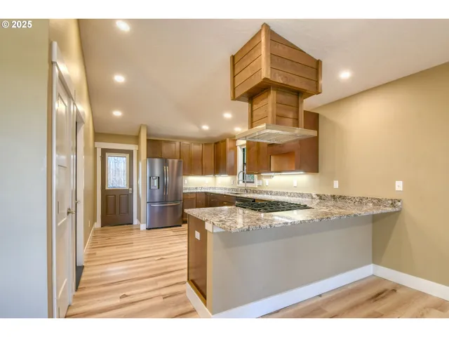 a kitchen with stainless steel appliances granite countertop a sink and a refrigerator