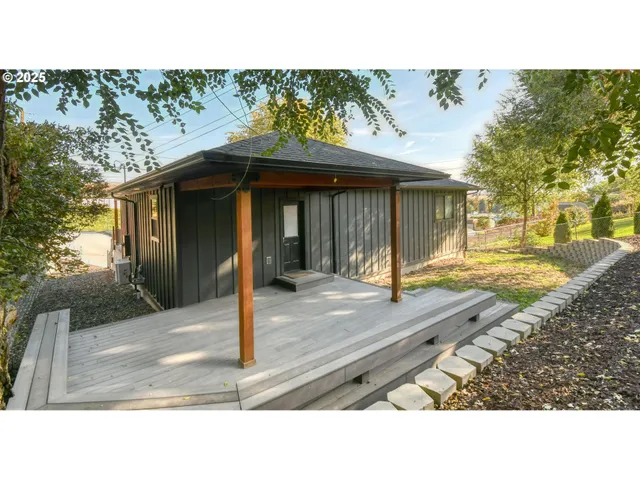 a view of a backyard with a tree and wooden fence