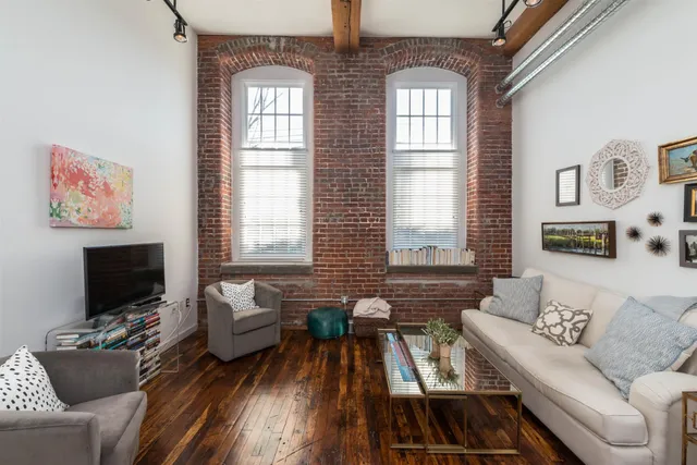 a living room with furniture a flat screen tv and a window