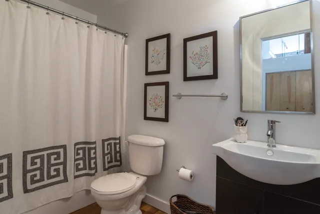 a bathroom with a toilet a sink and a mirror