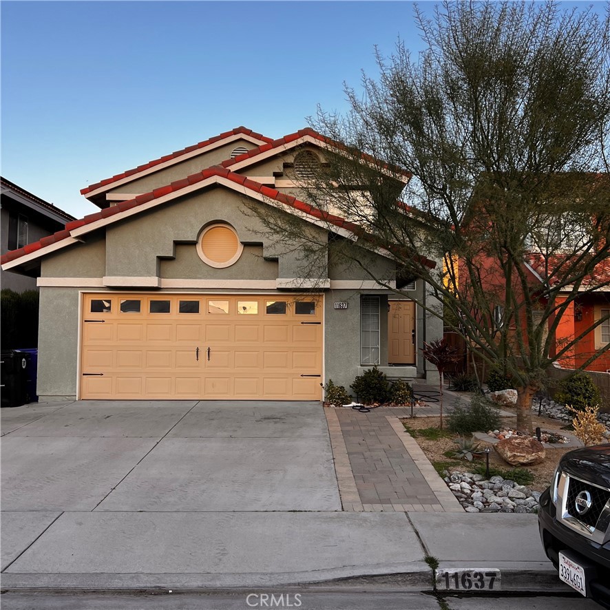 11637 Belmonte Road Fontana, CA 92337 - Photo 1 of 1 a front view of a house with garage and parking