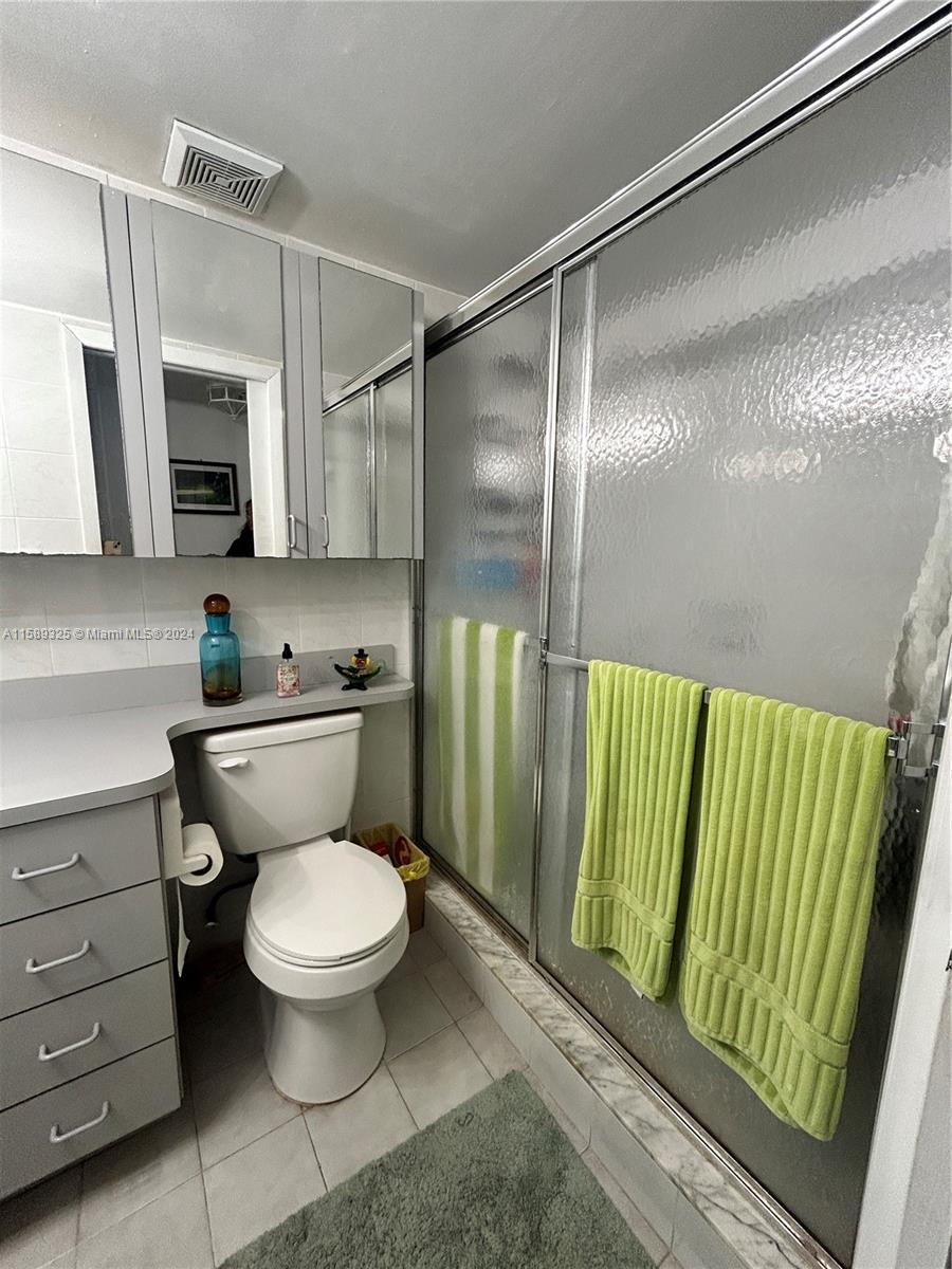 5050 Northwest 7th Street, Unit PH1 Miami, FL 33126 - Photo 19 of 36 a bathroom with a toilet a sink and a mirror