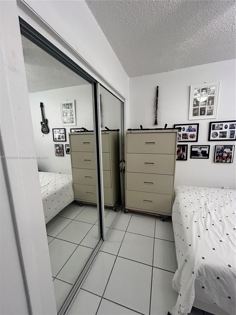 5050 Northwest 7th Street, Unit PH1 Miami, FL 33126 - Photo 21 of 36 a bedroom with a bed and a mirror