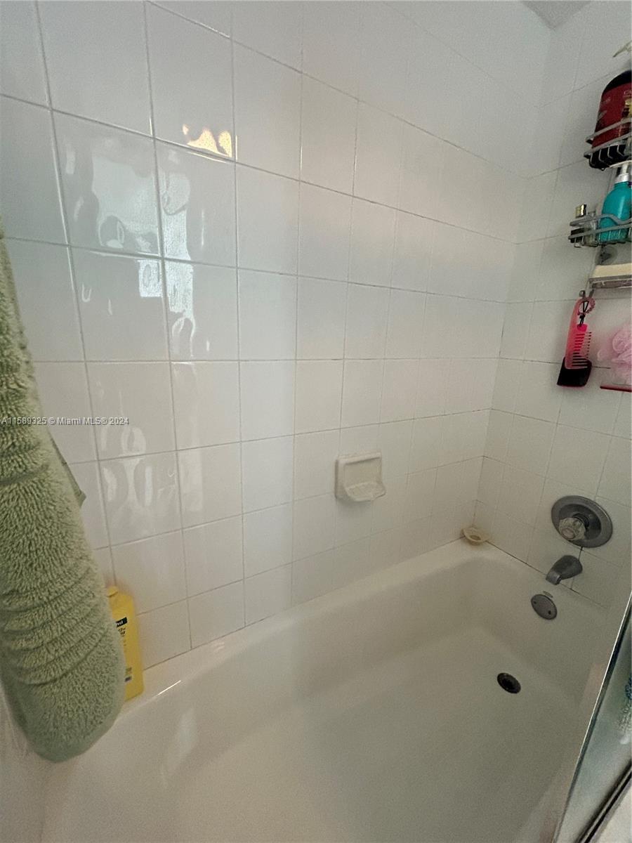 5050 Northwest 7th Street, Unit PH1 Miami, FL 33126 - Photo 25 of 36 a bathroom with a tub