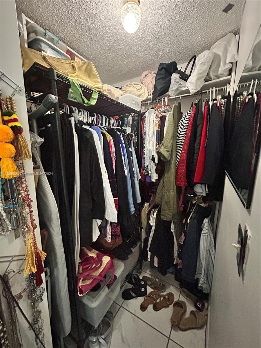 5050 Northwest 7th Street, Unit PH1 Miami, FL 33126 - Photo 26 of 36 a view of walk in closet with clothes and shoes