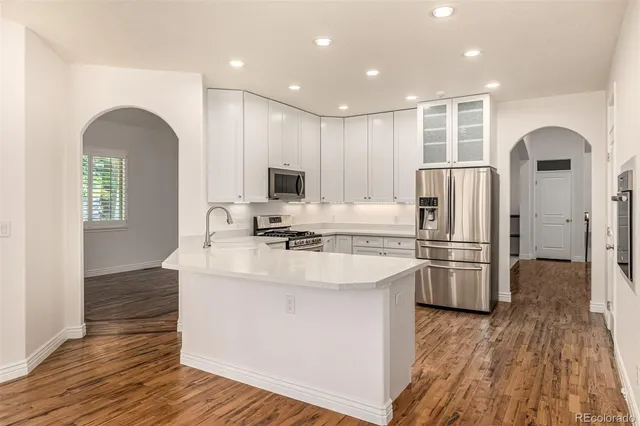 a kitchen with stainless steel appliances granite countertop a refrigerator sink and stove