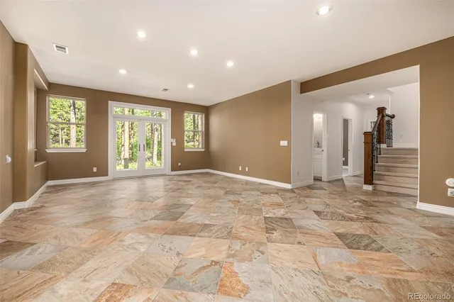 a view of an empty room with windows and chandelier