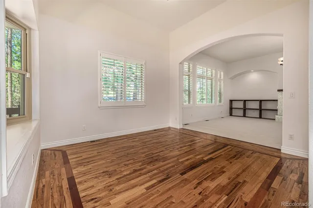 a view of a kitchen with stainless steel appliances granite countertop a refrigerator a stove and a wooden floors