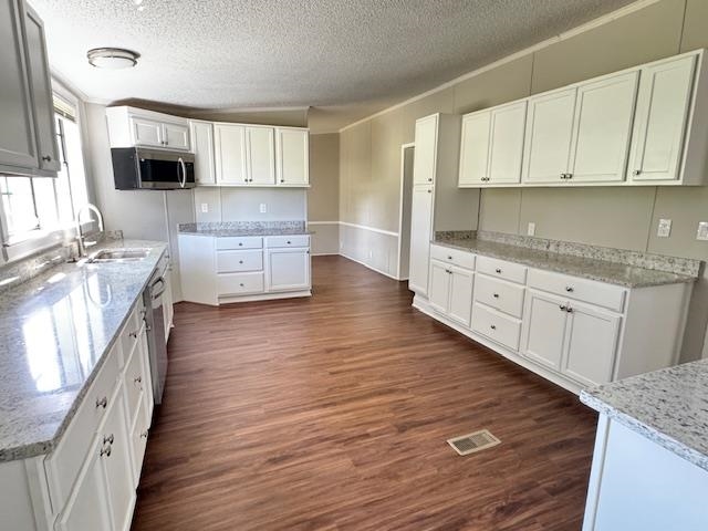281 Pintail Circle Drummonds, TN 38023 - Photo 6 of 26 a kitchen with granite countertop a stove top oven a sink dishwasher and white cabinets with wooden floor