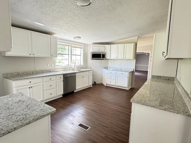 281 Pintail Circle Drummonds, TN 38023 - Photo 7 of 26 a kitchen with stainless steel appliances granite countertop a stove a sink and white cabinets with wooden floor