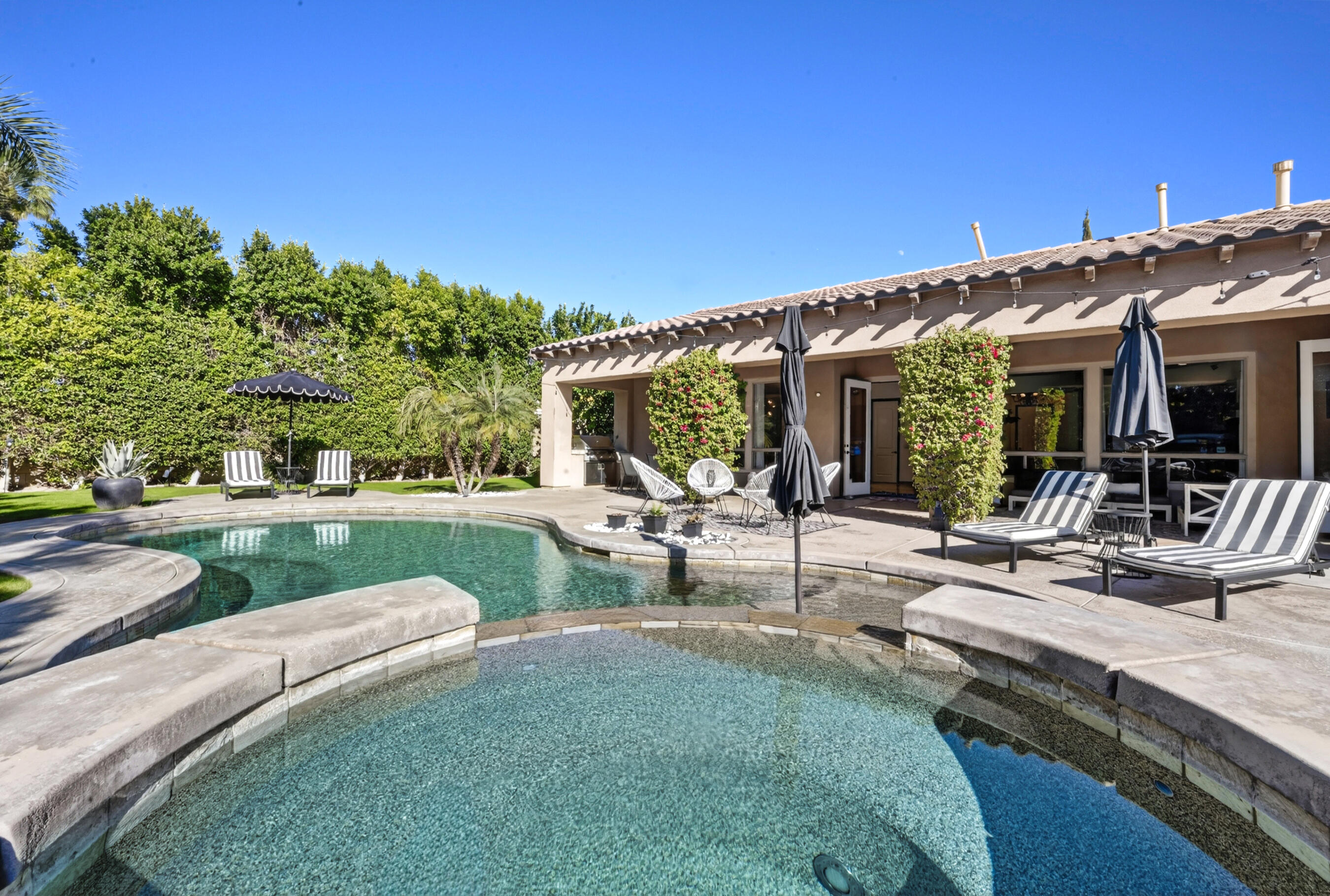 a view of a patio with couches and table and chairs under an umbrella