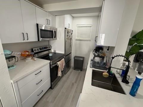 8607 Southwest 68th Court, Unit 27 Pinecrest, FL 33156 - Photo 3 of 9 a kitchen with white cabinets and appliances