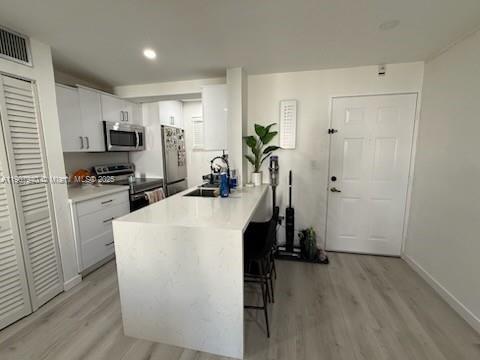 8607 Southwest 68th Court, Unit 27 Pinecrest, FL 33156 - Photo 4 of 9 a view of a kitchen with a sink wooden floor and a window